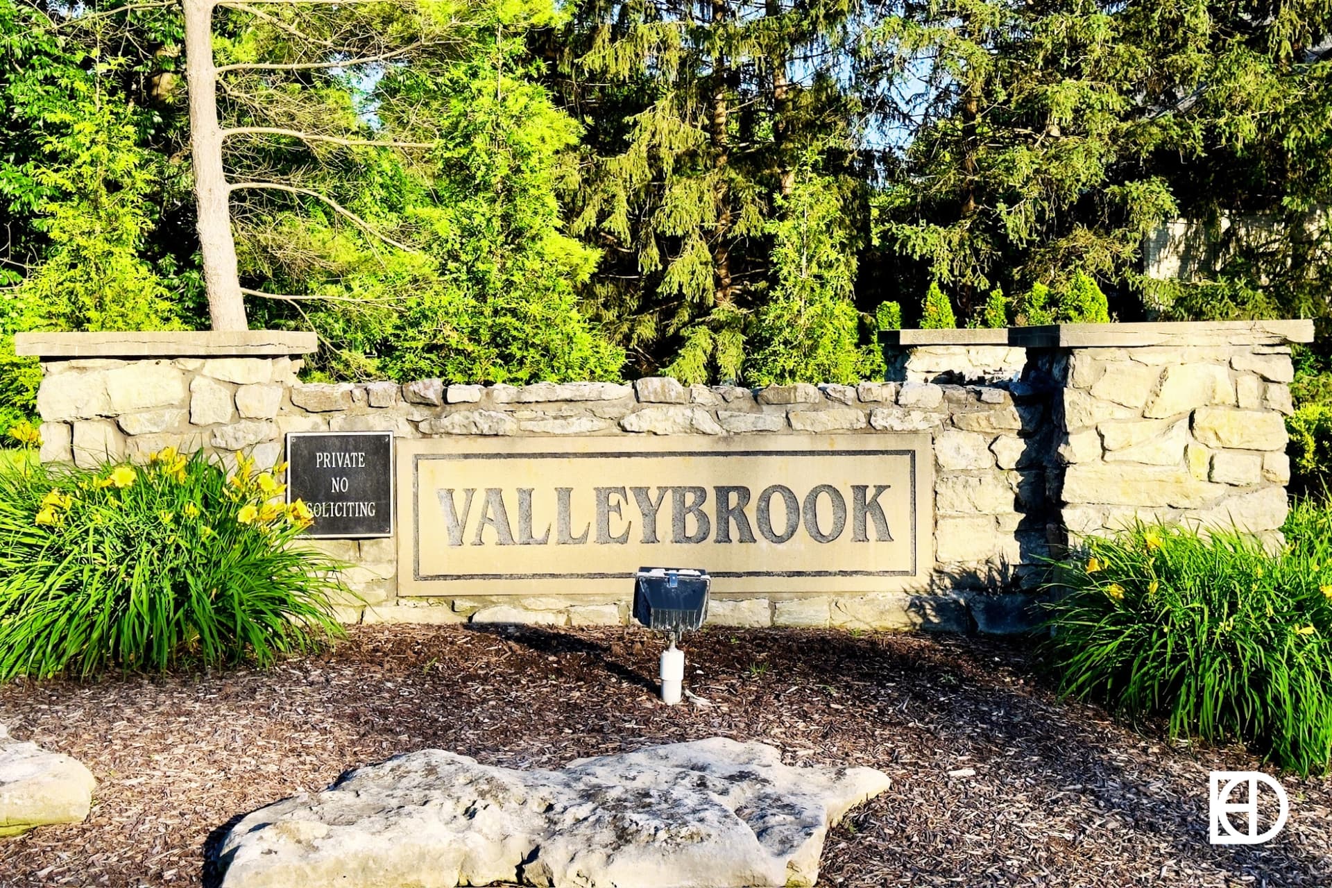 Photo of low stone wall with black letters for entrance sign to Valleybrook neighborhood.