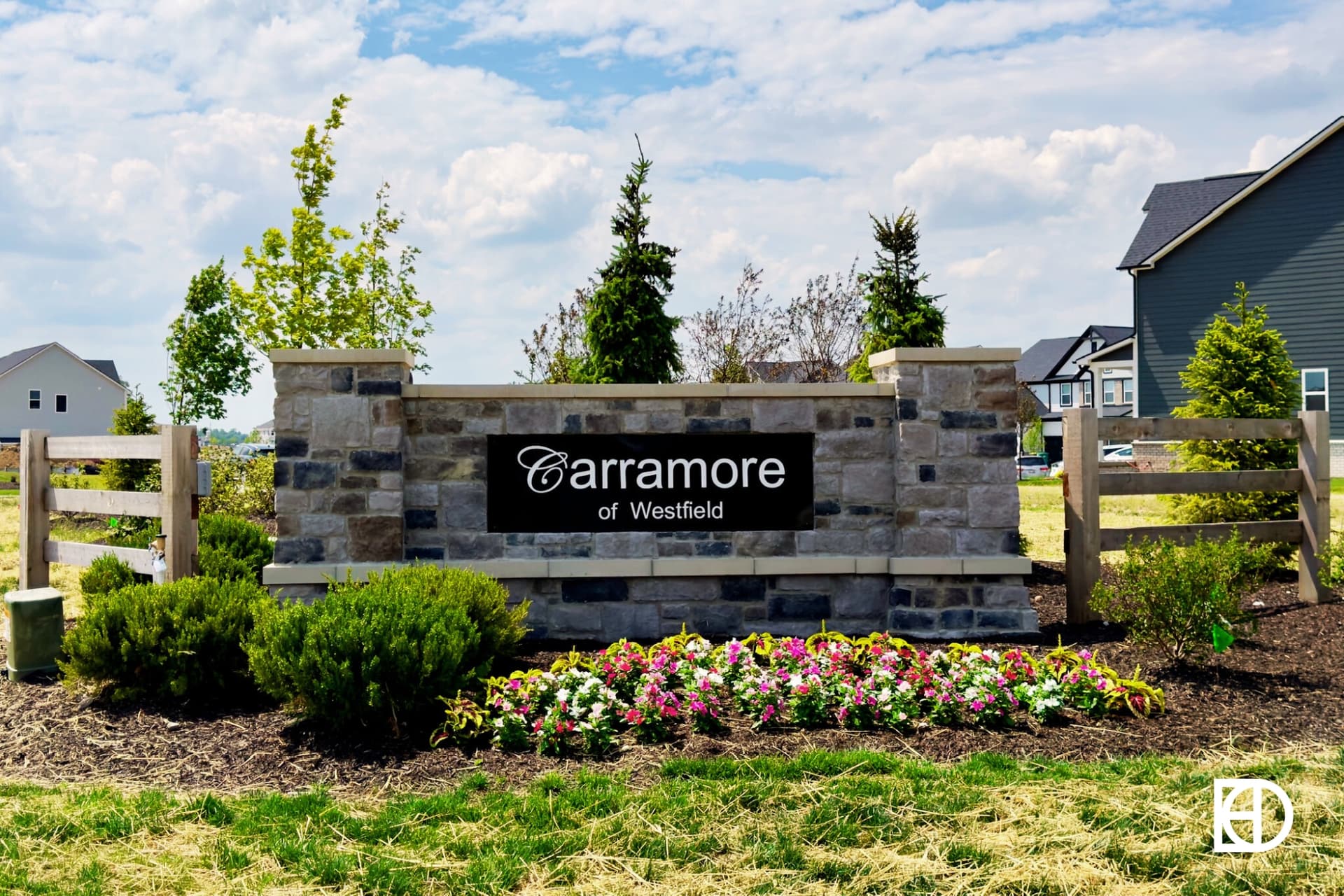 Stone entrance half wall with black sign and landscaping for Carramore of Westfield.