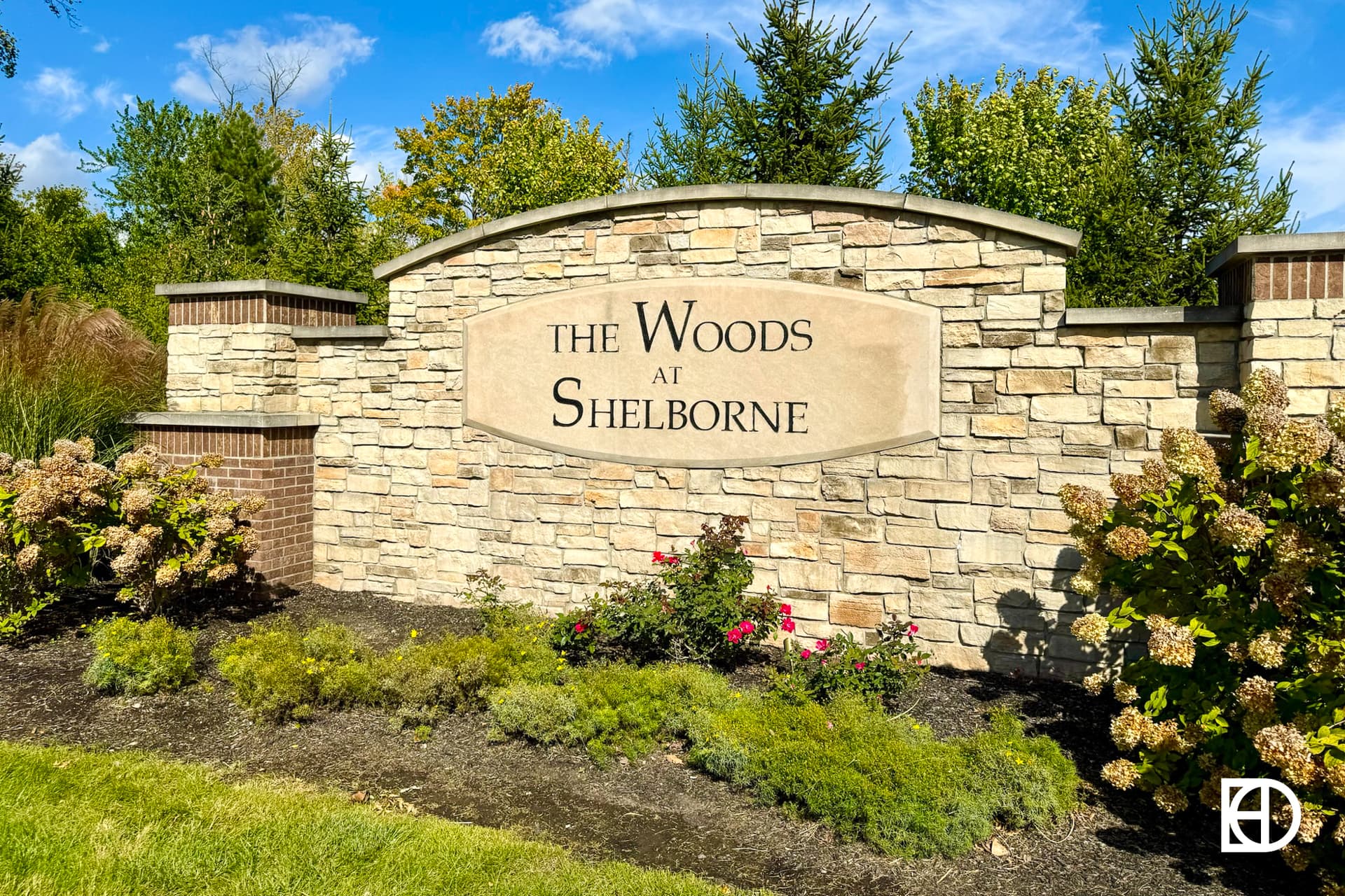Exterior photo of the Woods at Shelborne, showing signage and landscaping