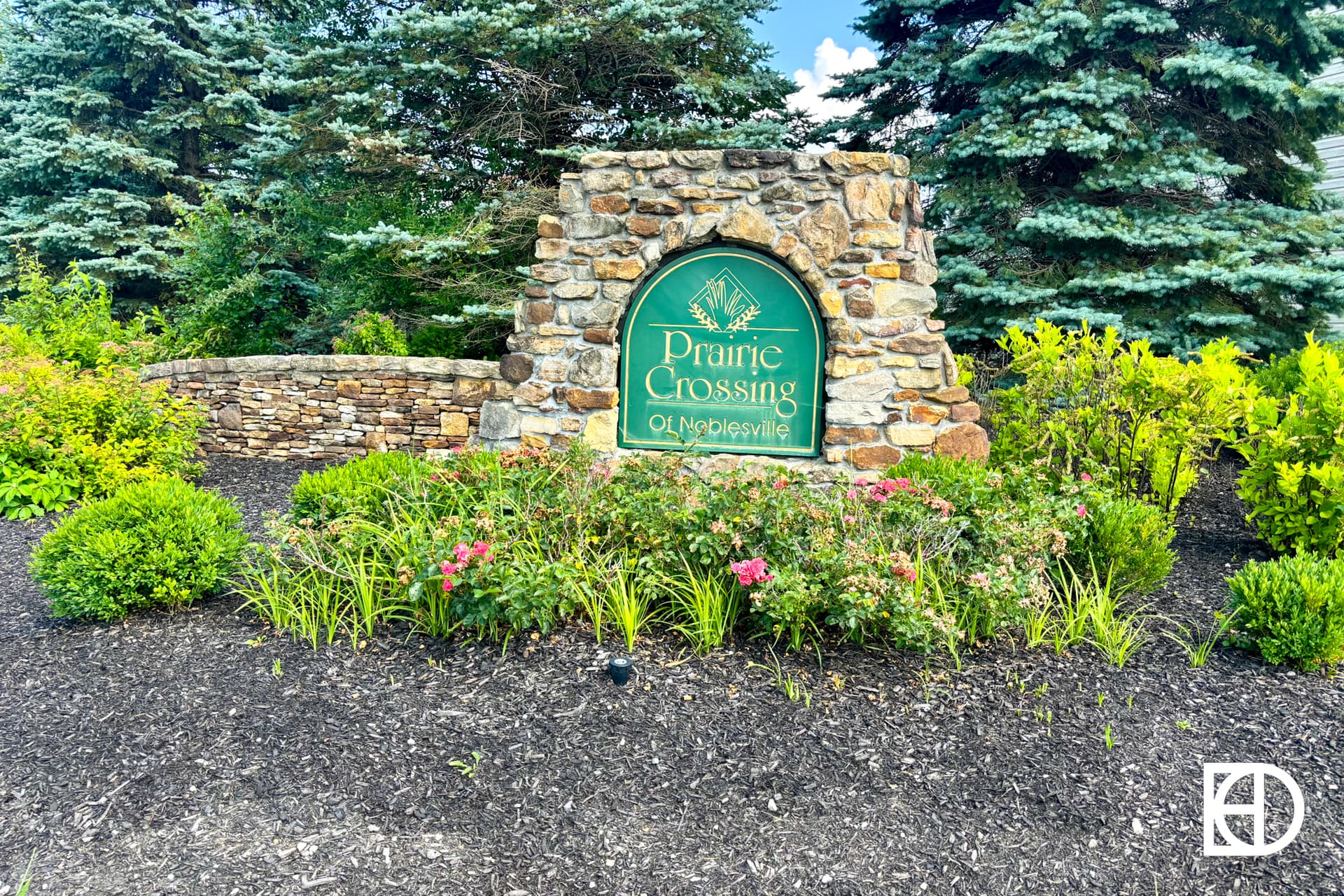 A sign in front of a stone wall.