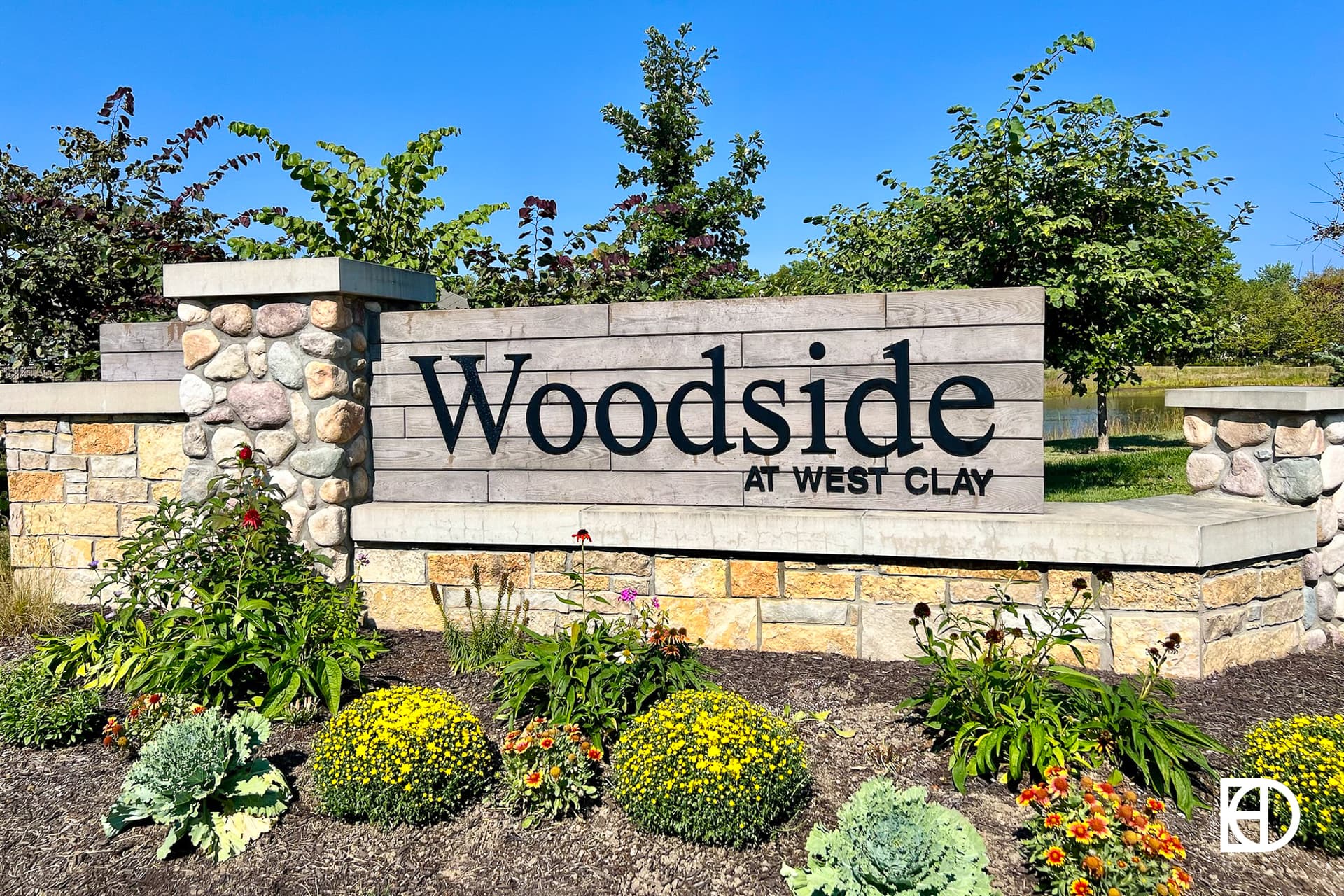 Exterior photo of Woodside at West Clay, showing signage and landscaping