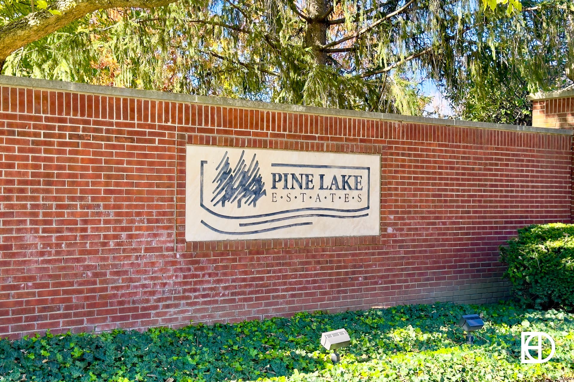 Exterior photo of Pine Lake Estates, showing entrance, signage, and landscaping