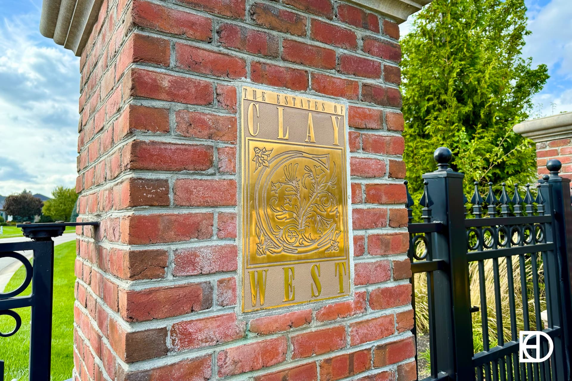 Exterior photo of Estates of Clay West, showing signage and landscaping