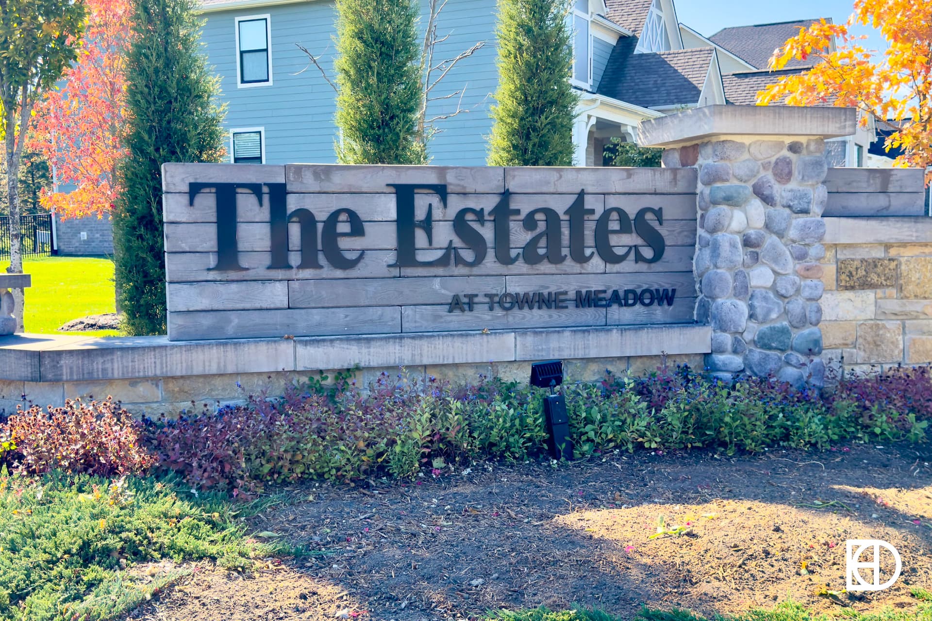 Exterior photo of The Estates at Towne Meadow, showing signage and landscaping