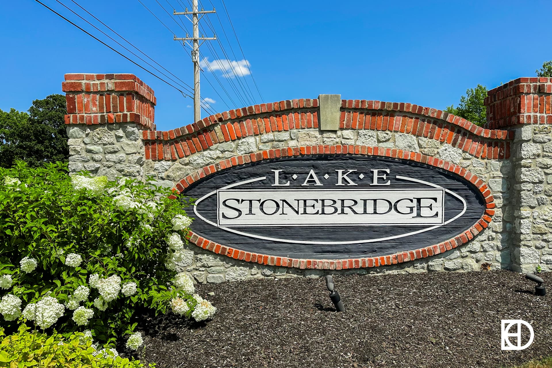 Exterior photo of Lake Stonebridge, showing signage on stone wall and landscaping