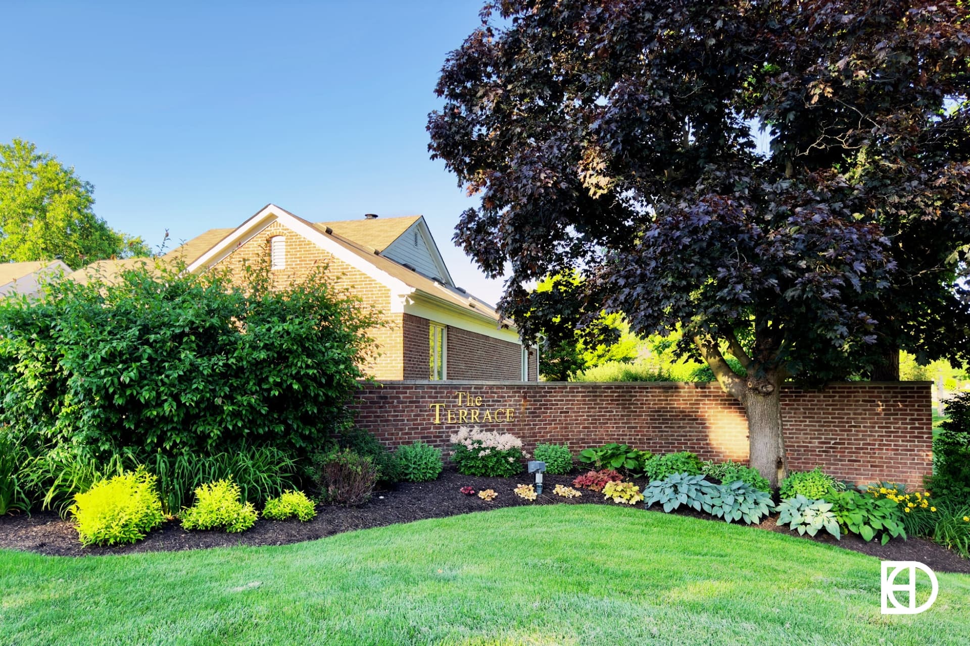 Exterior photo of Terrace at Mohawk Crossing, showing entrance with landscaping and signage