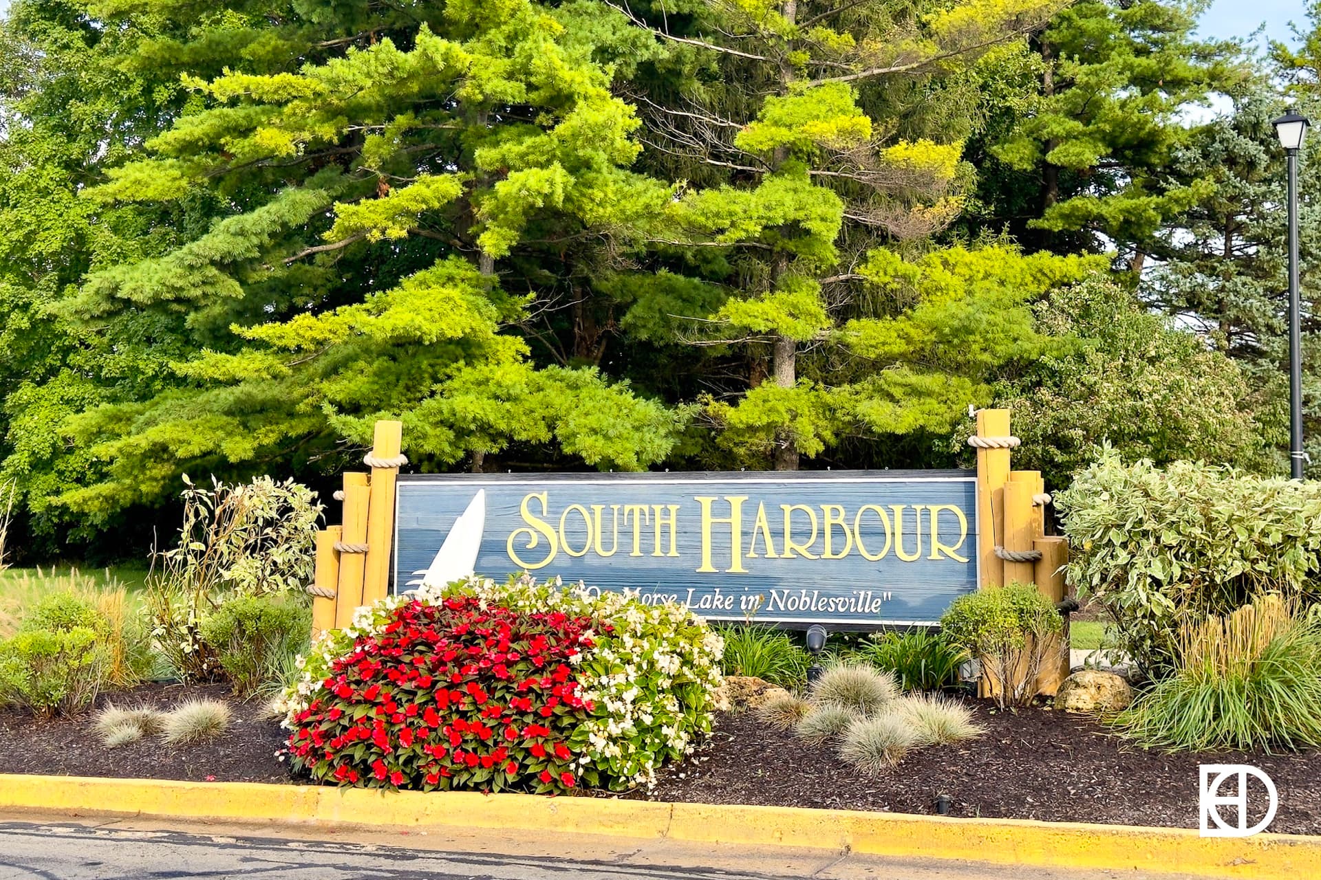 Entrance sign to South Harbour with flowers and trees in the background.