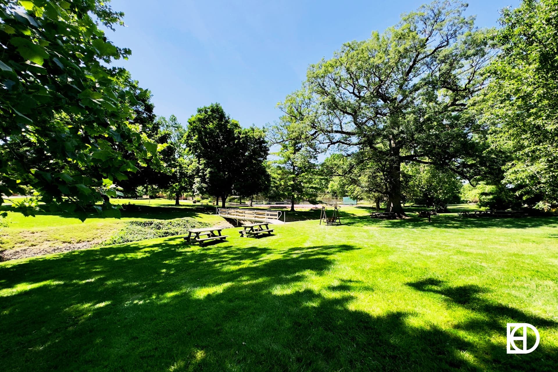 Photo of green space overlooking bridge over creek to Lake Woodland in The Woodlands neighborhood.