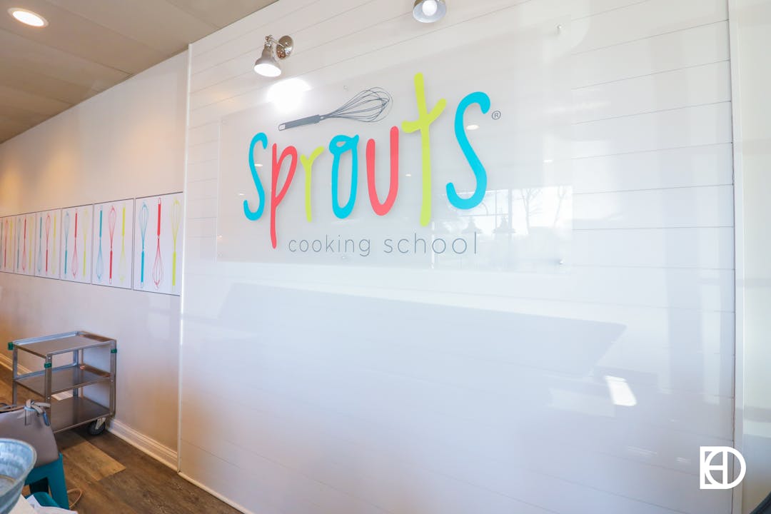 Interior photo of logo wall in Sprouts Cooking School.