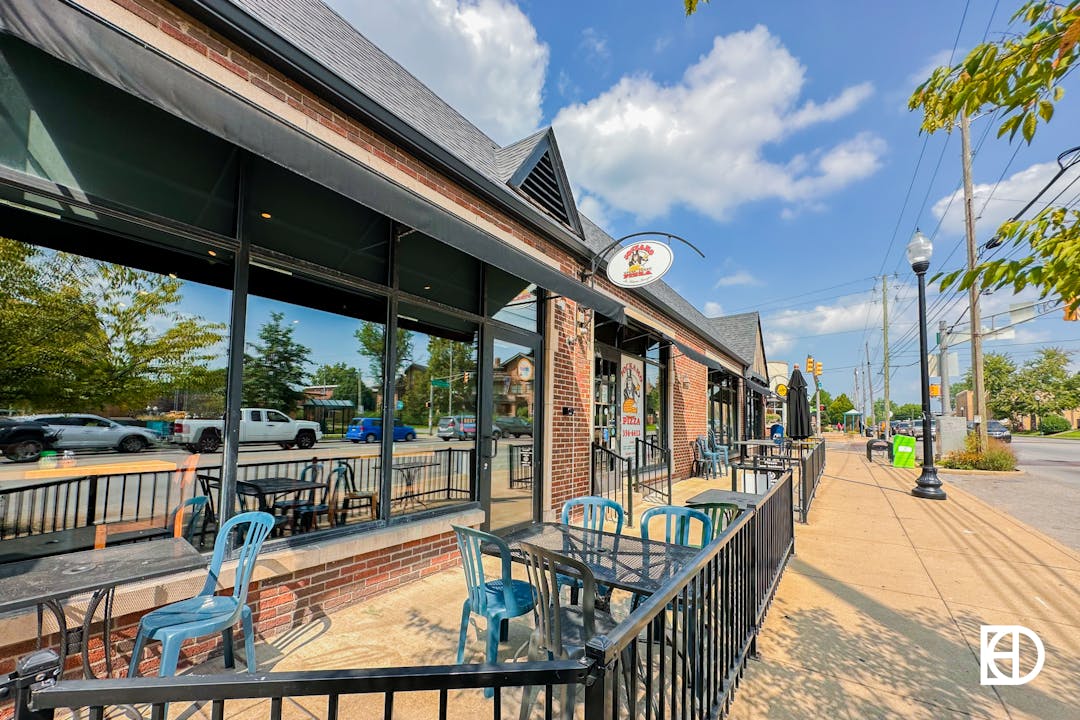 Exterior photo of Jockamo Pizza in Irvington on the East Side of Indianapolis, showing outdoor seating and signage